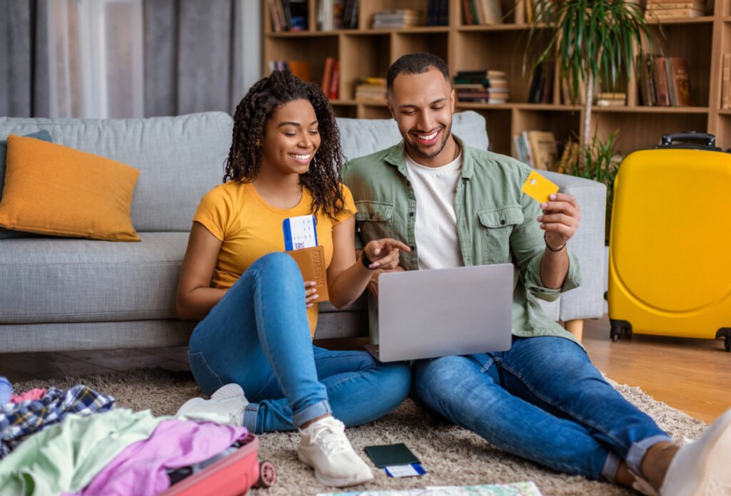 Couple booking flight and hotel for travel by redeeming points and rewards from a travel credit card.