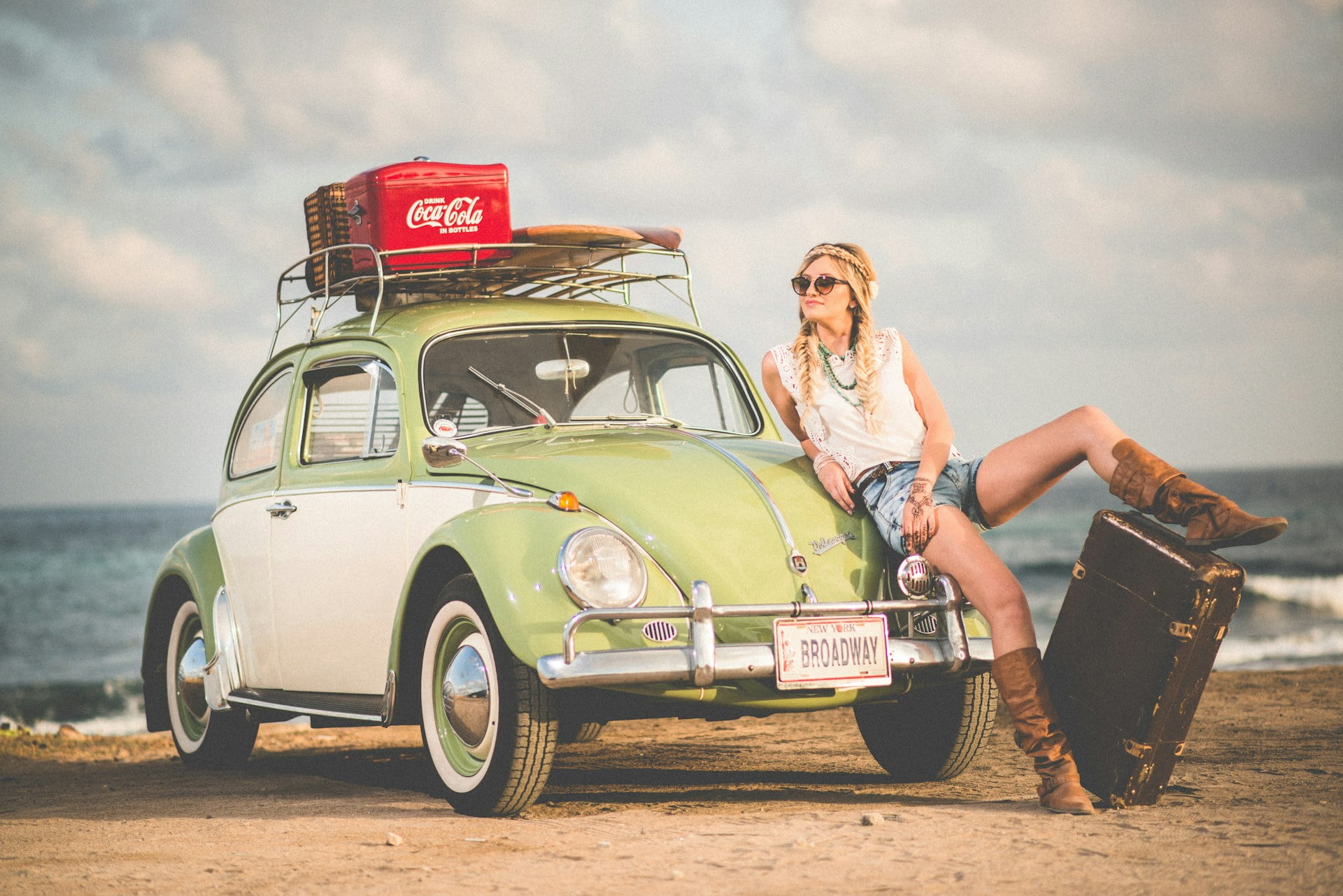 financial fomo header image girl sitting on VW beetle traveling